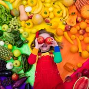 小女孩和各种各样的水果和蔬菜。Colorful rainbow of raw fresh fruits and vegetables. Child eating healthy snack. Vegetarian nutrition for kids. Vitamins for children. View from above.